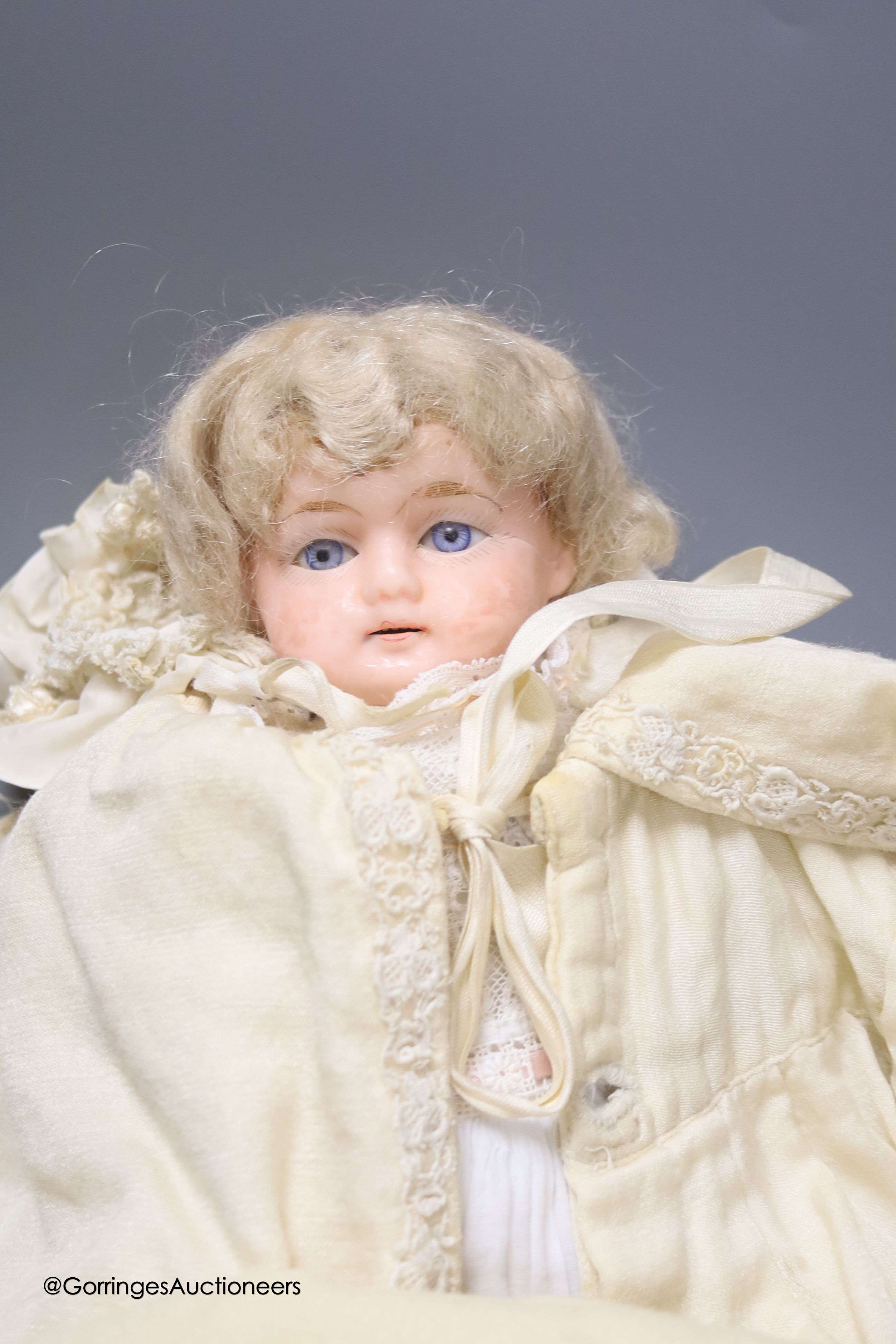 An antique wax doll, in original christening clothes, neck repaired, 12ins